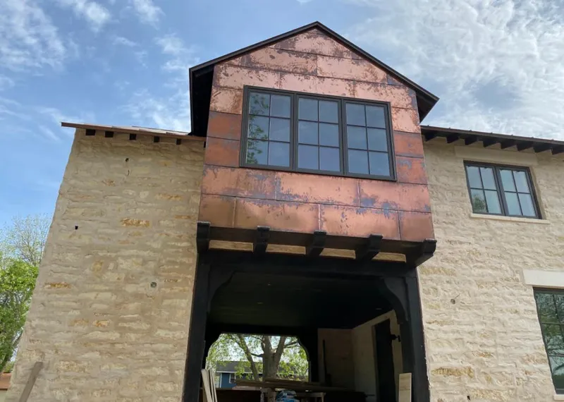 Copper metal panel facade on a stone building for Skylight Installation in Howell